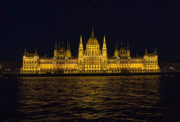 Sightseeing-Kreuzfahrtschiff, Das Auf Der Donau Am Beleuchteten Budapester Parlament Vorbeigleitet