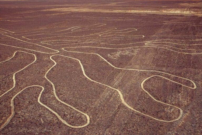 A Long Line Drawn On A Dirt Field With Nazca Lines In The Background