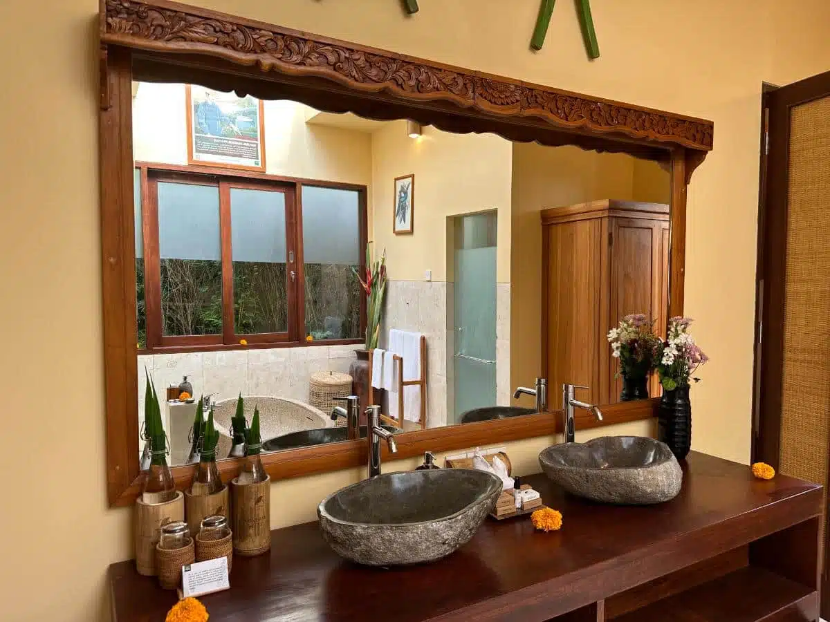 Dual Stone Vessel Sinks With Carved Teak Mirror And Organic Toiletries In The Villa Bathroom At Munduk Moding Plantation, Bali
