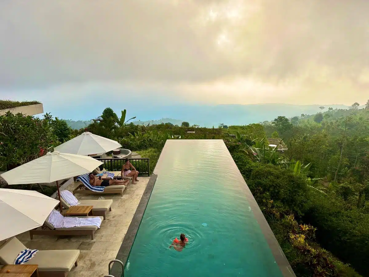 Lower Infinity Pool At Sunset With Lush Tropical Vegetation At Munduk Moding Plantation Eco-Luxury Resort, Bali Highlands