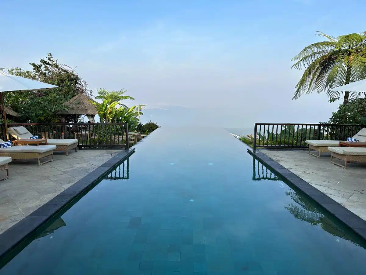 Guests Relaxing In The Upper Infinity Pool Overlooking The North Bali Rainforest At Munduk Moding Plantation Nature Resort