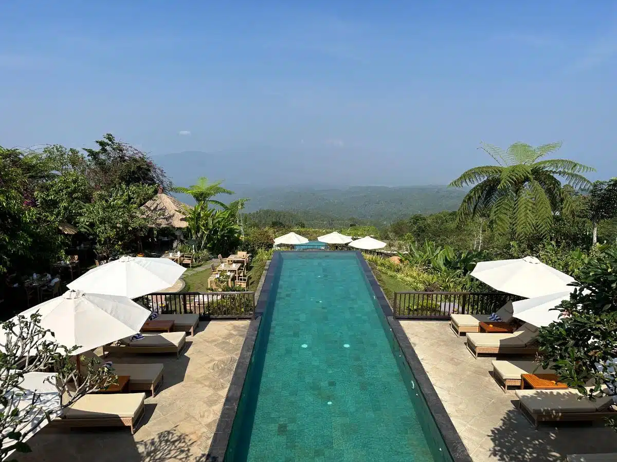 Upper Infinity Lap Pool With Sun Loungers, White Umbrellas, And Sweeping Rainforest Panorama At Munduk Moding Plantation, Bali