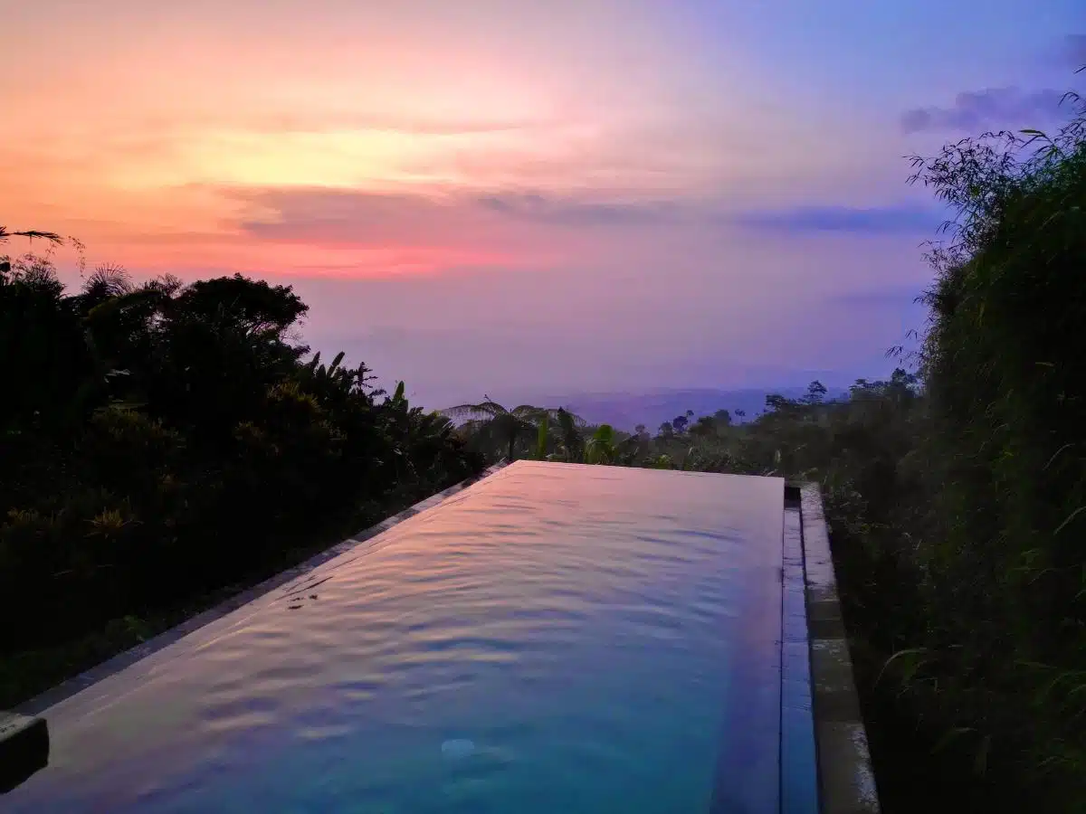 Dramatic Sunset With Pink And Purple Sky Reflecting On The Private Villa Infinity Pool At Munduk Moding Plantation, North Bali