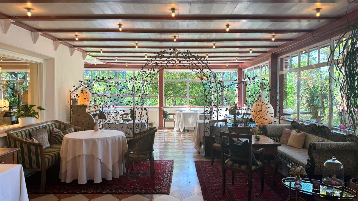 Prezioso Michelin-Starred Restaurant Salon At Castel Fragsburg With Wrought Iron Floral Arches, Persian Rug, And Garden-View Windows In Merano