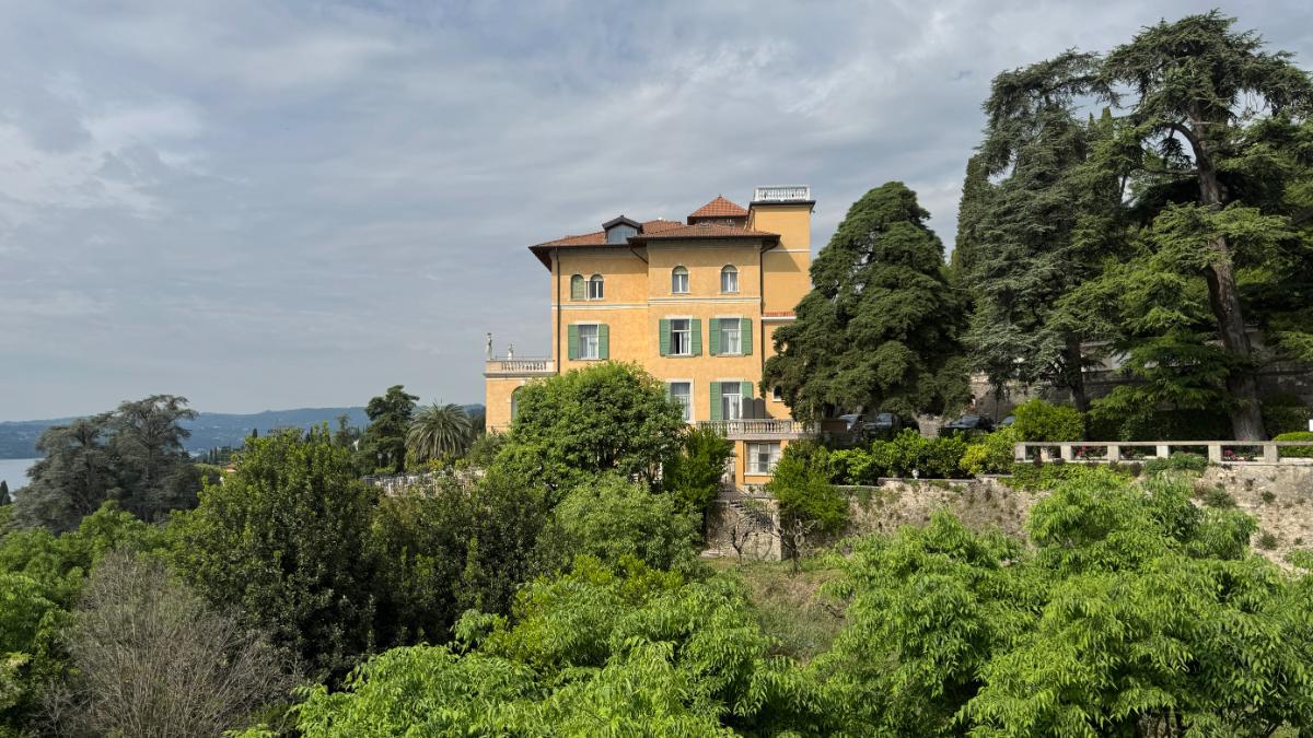Historic Villa Del Sogno Hotel With Yellow Facade And Green Shutters Set Among Lush Gardens Above Lake Garda On The Riviera Dei Limoni, Italy