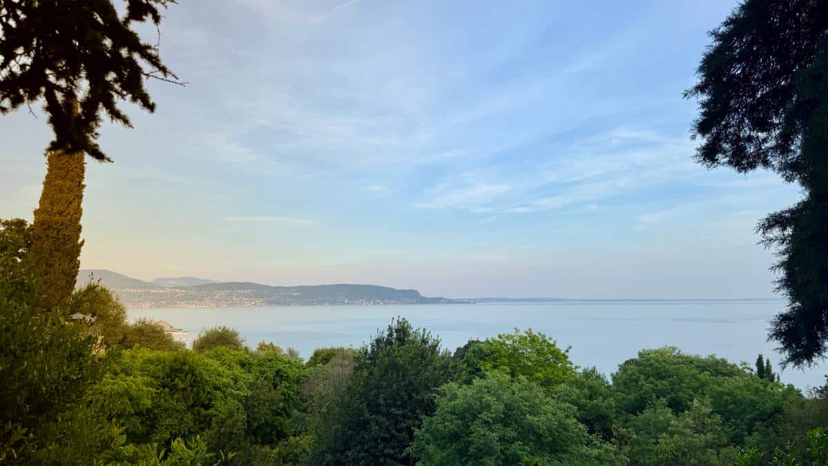 Sunset View Of Lake Garda Framed By Cypress Trees And Lush Gardens From The Grounds Of Villa Del Sogno In Gardone Riviera, Italy